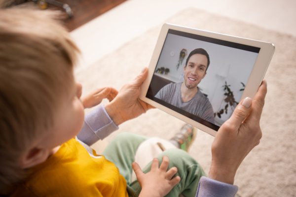 close-up-mother-holding-tablet-showing-son-while-connecting-father-via-videoconferencing-app-scaled.jpg